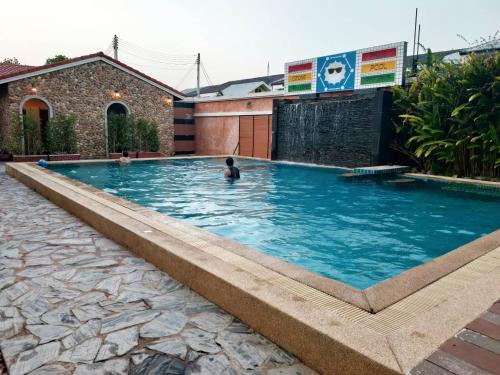 a man swimming in a large swimming pool at Welnez World Residence Pattaya in Pattaya Central