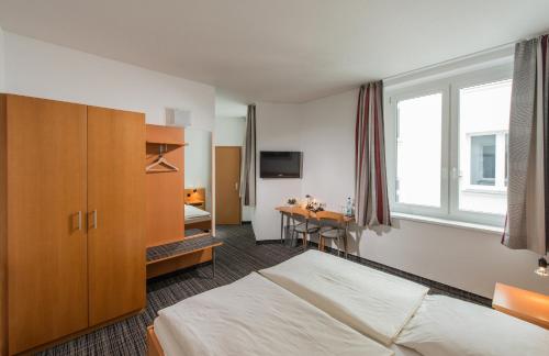 a hotel room with a bed and a desk at City Hotel in Eisenach