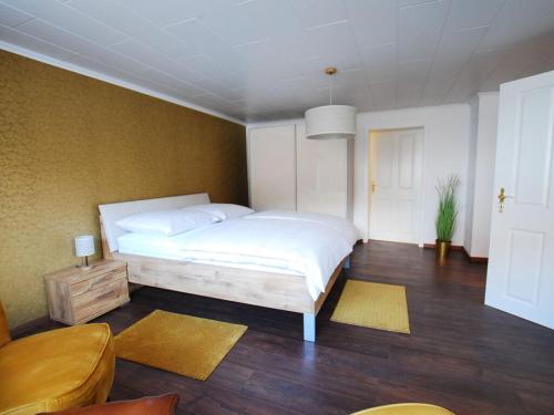 a bedroom with a white bed and a wooden floor at Holiday house on Bornfeld in Leimen