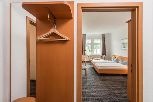 a living room with a bed and a room with a hallway at City Hotel in Eisenach