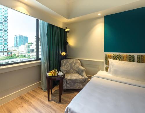 Saigon Prince Hotel في مدينة هوشي منه: غرفه فندقيه بسرير وكرسي ونافذه