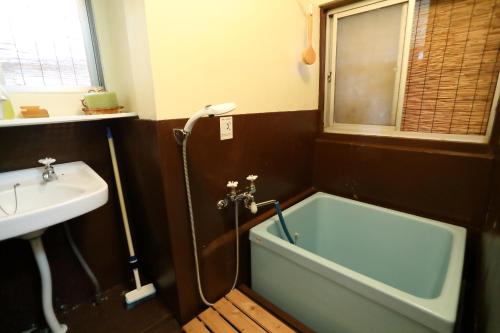 a bathroom with a bath tub and a sink at 棚田ハウス 