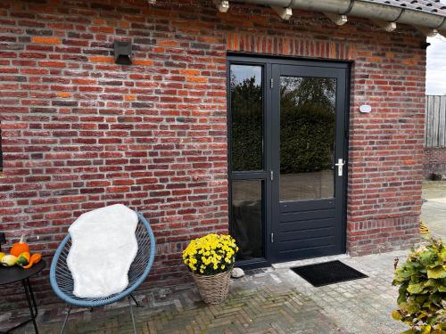 a brick building with a door and a basket of flowers at Bed and Breakfast De Beekhoek in Glane