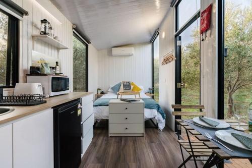 een tiny house met een keuken en een slaapkamer bij Olive Grove Retreat 1 in Lake Boga