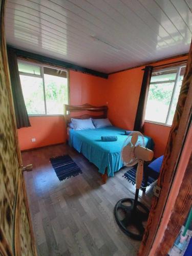 a bedroom with a bed in a room with orange walls at Marupo Room in Fare