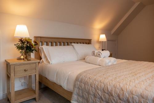 a bedroom with a large bed and a nightstand with a bed sidx sidx sidx at Forest Corner Luxury Apartment with Hot Tub in North Ballachulish