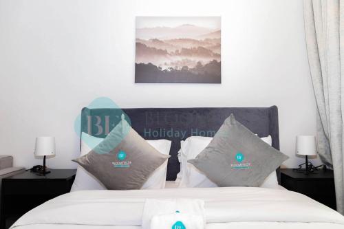 Schlafzimmer mit einem Bett mit weißer Bettwäsche und Kissen in der Unterkunft Classic Studio In Oasis in Abu Dhabi