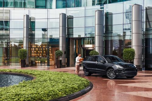 a man standing next to a black car in front of a building at Jumeirah Living World Trade Centre Dubai in Dubai