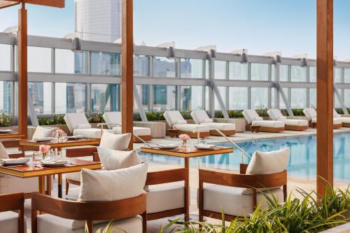 un restaurante con piscina, mesas y sillas en Jumeirah Living World Trade Centre Residence, Suites and Hotel Apartments en Dubái