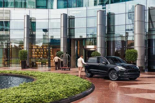 a man standing next to a black car in front of a building at Jumeirah Living World Trade Centre Dubai in Dubai