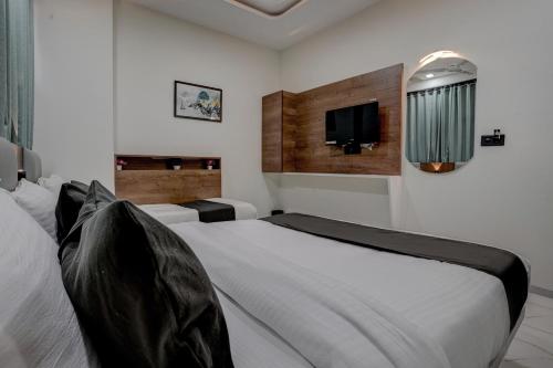a bedroom with a bed and a tv on the wall at Hotel Paris inn in Ahmedabad