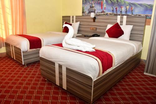 Dos camas en una habitación de hotel con un cisne. en Hotel Jiyan Hospitality Pvt. Ltd., en Dhangadhi