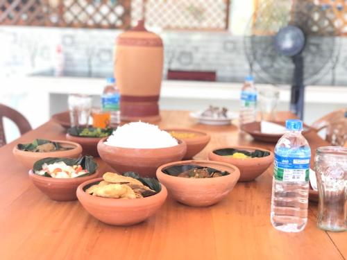 a table with bowls of food and a bottle of water at Glitz Marriott in Deniyaya