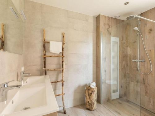 a bathroom with a white sink and a shower at Holiday home Chill on Ameland in Ballum