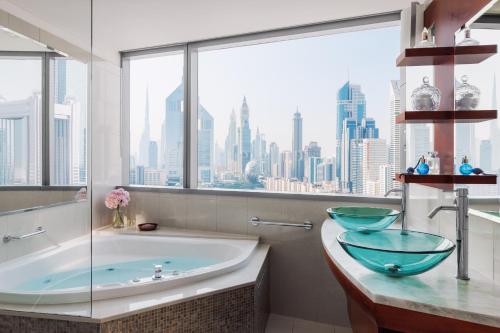 a bathroom with a tub and a large window at Jumeirah Living World Trade Centre Residence, Suites and Hotel Apartments in Dubai