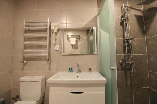 een badkamer met een wastafel, een toilet en een douche bij Baku ZamZam Hotel in Baku