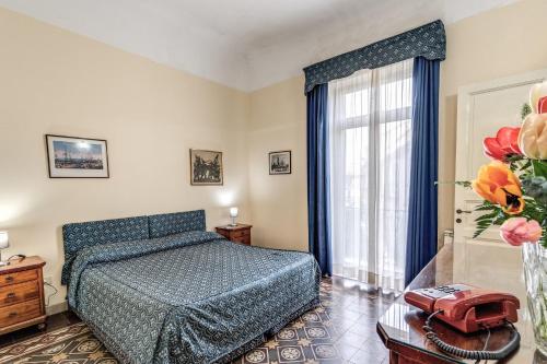 メッシーナにあるホテル ラ レジデンツァのベッドルーム1室(ベッド1台、花瓶1本付)