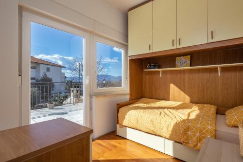 um quarto com uma cama e uma grande janela em Apartman Lavanda em Kostrena