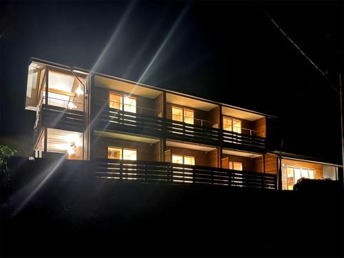 a large apartment building with its lights on at night at guesthouse Amami Long Beach2 in Koshuku