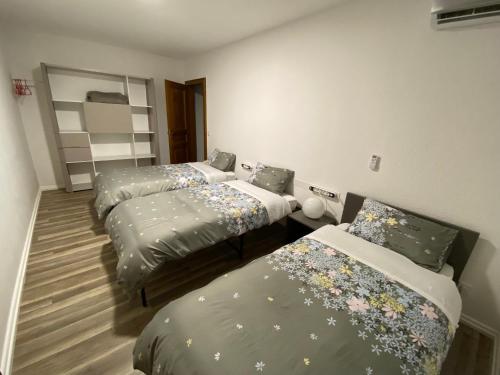 a room with three beds with flowers on them at Appartement 50M² in Seltz