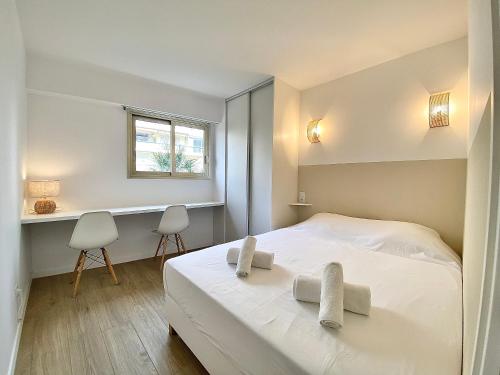 une chambre avec un lit blanc et une fenêtre dans l'établissement Appartement Cannes 2 chambres - 14J, à Cannes