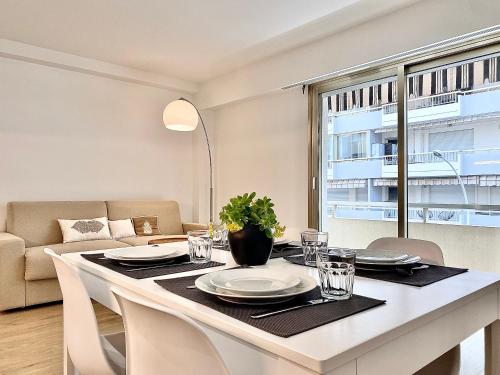 une table de salle à manger avec des assiettes et des verres dessus dans l'établissement Appartement Cannes 2 chambres - 14J, à Cannes