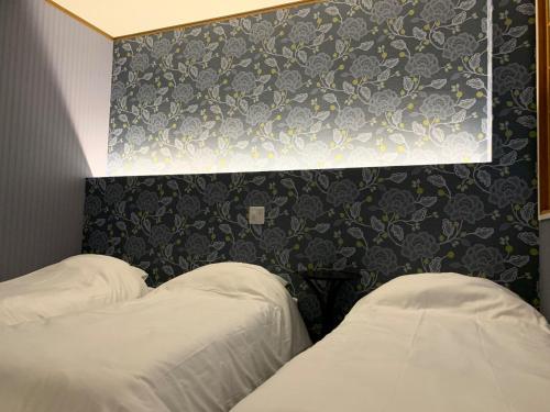 two beds in a hotel room with a floral wall at AO Dazaifu / Vacation STAY 61732 in Chikushino