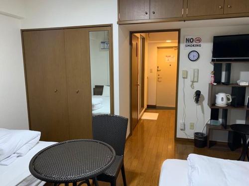 Zimmer mit 2 Betten, einem Tisch und einem Nichtraucherschild in der Unterkunft AO Dazaifu / Vacation STAY 61720 in Chikushino