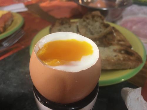un huevo duro en un plato verde con tostadas en Le coin tranquille, en Morosaglia
