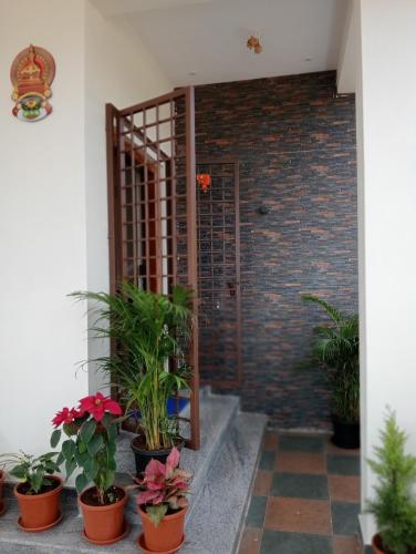 a room with potted plants and a brick wall at Sai Nivas Guest House Coorg in Kushālnagar