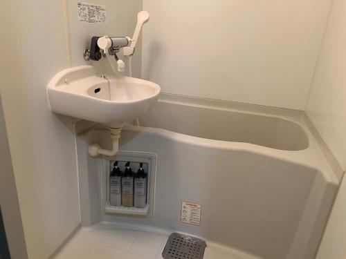 een kleine badkamer met een wastafel en flessen wijn bij AO Dazaifu - Vacation STAY 93787 in Chikushino