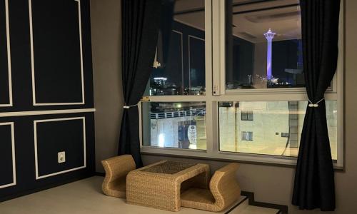 a room with a window with wicker chairs and a bench at Radiant Nampo Hotel in Busan