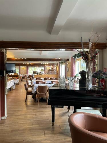 a restaurant with a piano in the middle of a room at Hôtel Chastellares in Auron