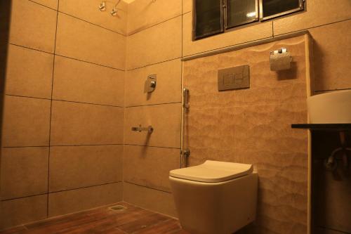 a bathroom with a toilet and a shower at Ponni Homestay Kumbakonam in Kumbakonam