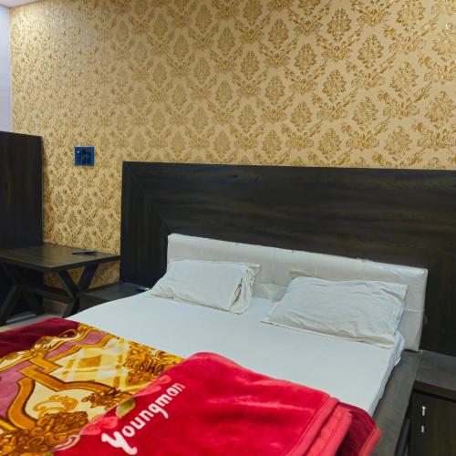 Un dormitorio con una cama con una manta roja. en VIJAY RESTAURANT, en Sihorā