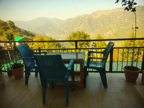 a table and chairs on a balcony with a view at The Moon Light Home stay in Bhīm Tāl