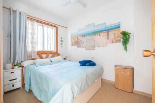 Un dormitorio con una cama con una bolsa azul. en PRIMERA LINEA Playa Romana Frontal al Mar ALBERT VILLAS en Alcocéber