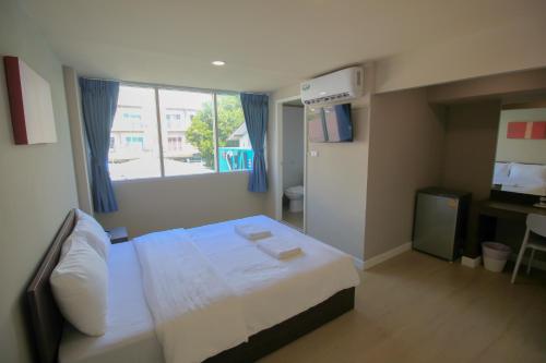 a hotel room with a bed and a window at The Sea Bangsaen Hotel in Ban Bang Saen (1)