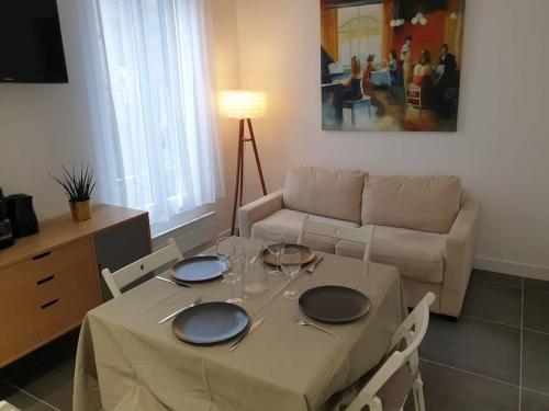 un salon avec une table et un canapé dans l'établissement Bel appartement avec patio, à Villejuif