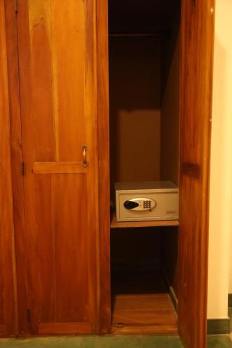 a door to a cabinet with a microwave in it at Ceylon Ayu Resort Kandy in Kandy