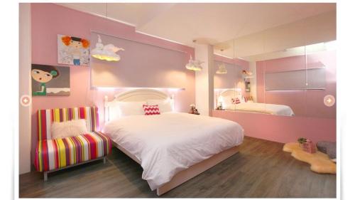 a pink bedroom with a bed and a mirror at Zebra Babala B&B in Dongshan