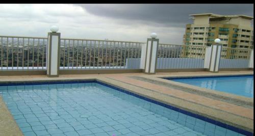 a swimming pool on the roof of a building at 1BR Condo Unit W/ Fantastic View near US Embassy in Manila