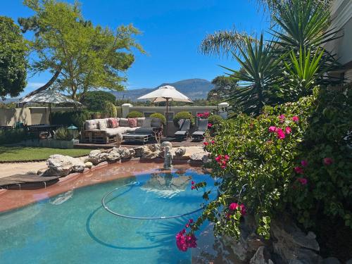 a swimming pool with a fountain in a yard at Kaya La Provence in Cape Town