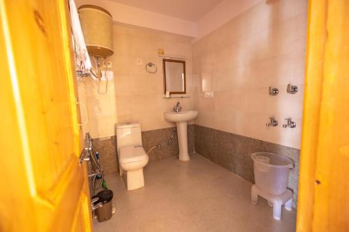 a bathroom with a toilet and a sink at Adventure Valley in Manāli