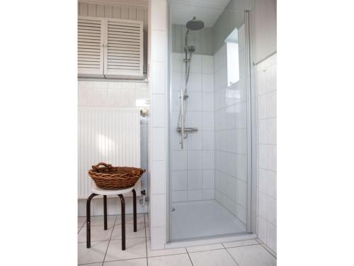a bathroom with a shower with a chair and a stool at Holiday home Zum Nagel in Pommerby