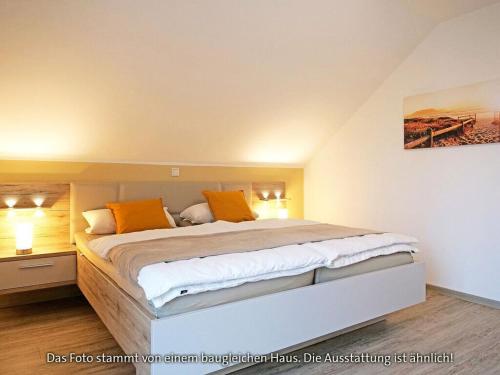 a bedroom with a large bed with orange pillows at Holiday home sea breeze in Burhave