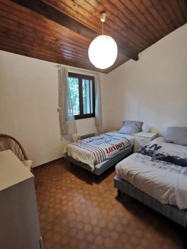 une chambre avec deux lits et une fenêtre dans l'établissement Villa avec piscine sur terrain clôt, à Méjannes-le-Clap
