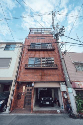 a brick building with a car in the garage at 唐風家 北田辺 近邻地铁 3階 in Osaka