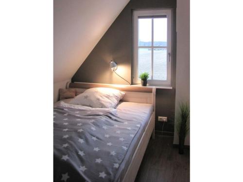 a bed in a room with a window at Thatched cottage Starfish in Zierow
