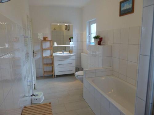 a bathroom with a tub and a toilet and a sink at Baltic Sea Fördeblick in Langballig